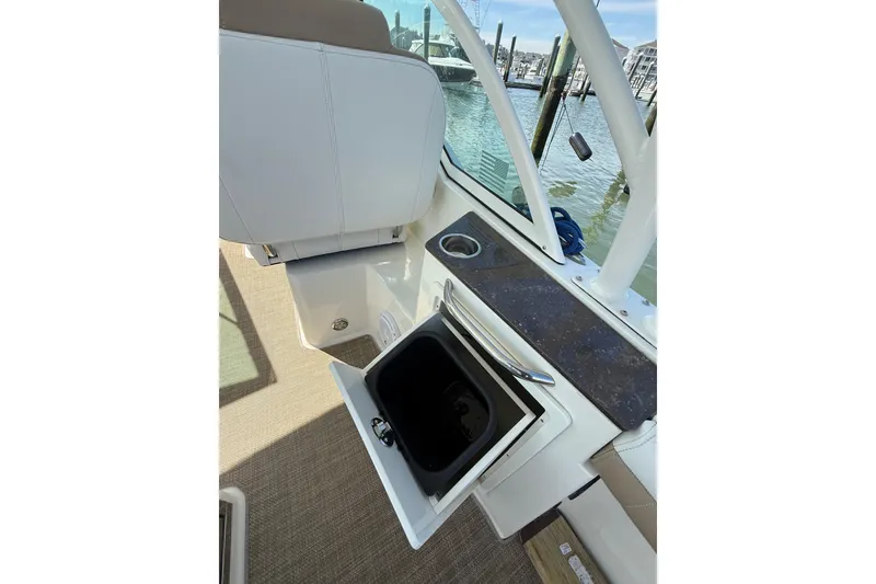 Slide: The Image of 2019 World Cat Glacier Bay Edition 2740 Dual Console boat interior with open storage compartment. - 30