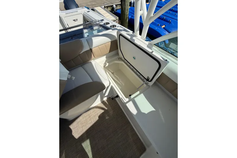 Slide: The Image of 2019 World Cat Glacier Bay Edition 2740 Dual Console interior with open storage compartment. - 32