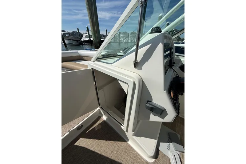 Slide: The Image of 2019 World Cat Glacier Bay Edition 2740 Dual Console interior with open storage compartment. - 39