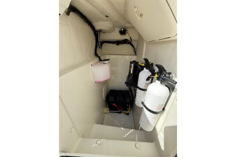 Slide: The Image of 2019 World Cat Glacier Bay Edition 2740 Dual Console storage area with fire extinguishers and wiring. - 40