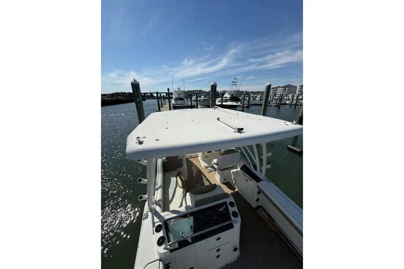 Slide: The Image of 2019 World Cat Glacier Bay Edition 2740 Dual Console docked at marina under clear blue sky. - 52