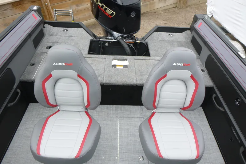 Slide: The Image of 2025 Alumacraft Trophy 185X Sport boat interior with two gray and red seats. - 11