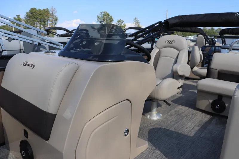 Slide: The Image of 2026 Bentley Pontoons Fish 220 4-Point interior with beige seating and steering console. - 3