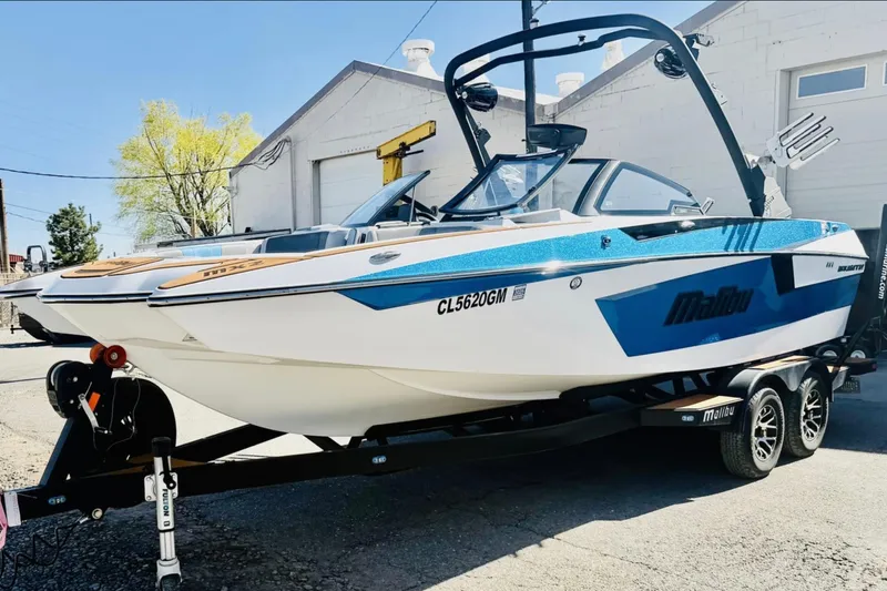 The Image of 2021 Malibu Wakesetter 23 MXZ boat on trailer, parked outdoors. - 1
