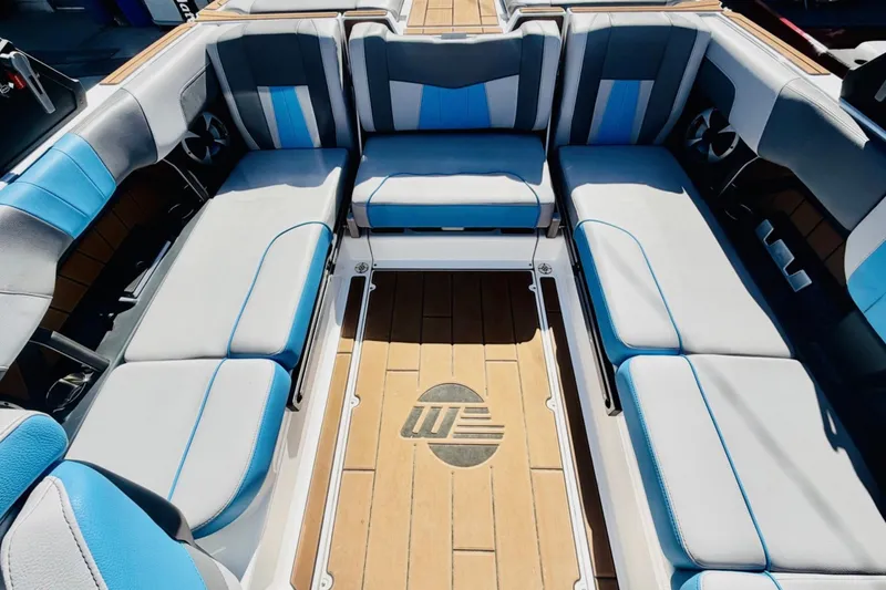 Slide: The Image of 2021 Malibu Wakesetter 23 MXZ interior with blue and gray seating, teak flooring. - 10
