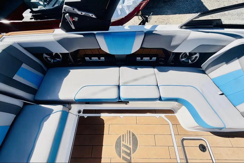 Slide: The Image of 2021 Malibu Wakesetter 23 MXZ interior with blue and gray seating, teak flooring. - 13