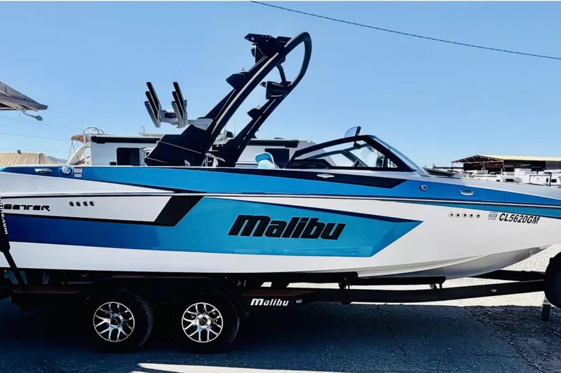 Slide: The Image of 2021 Malibu Wakesetter 23 MXZ boat on trailer, featuring sleek blue and white design. - 6