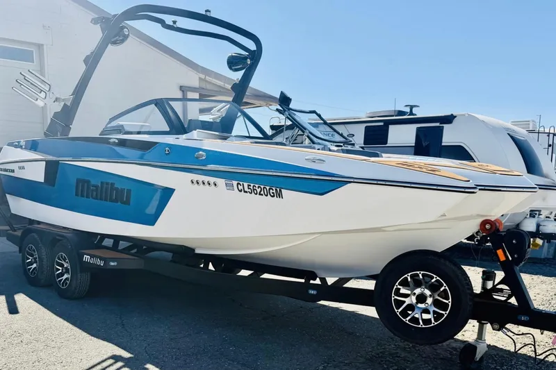 Slide: The Image of 2021 Malibu Wakesetter 23 MXZ boat on trailer, blue and white design. - 7
