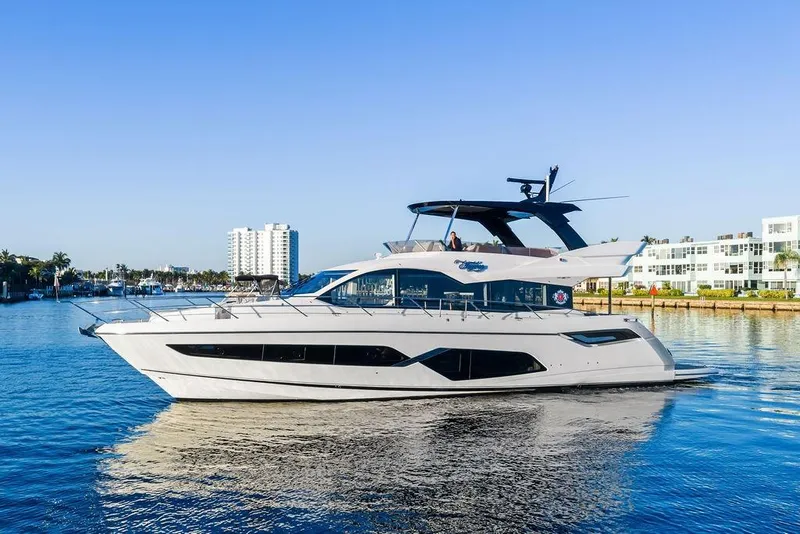 The Image of 2021 Sunseeker Manhattan 68 yacht cruising on a sunny day near waterfront buildings. - 0