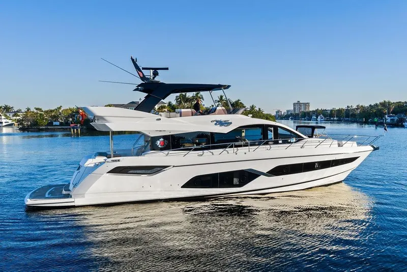 Slide: The Image of 2021 Sunseeker Manhattan 68 yacht cruising on a sunny day, showcasing sleek design. - 11