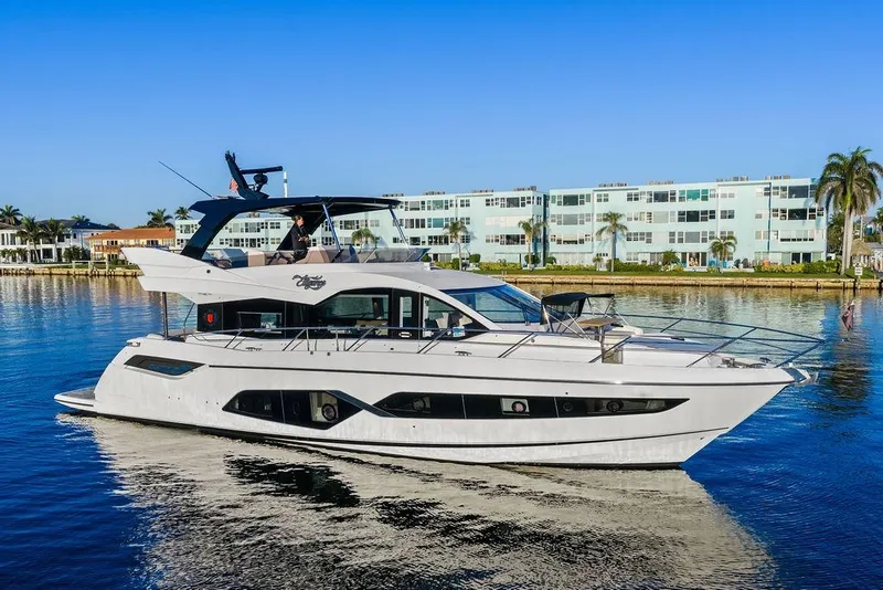 Slide: The Image of 2021 Sunseeker Manhattan 68 yacht cruising near modern waterfront buildings. - 14