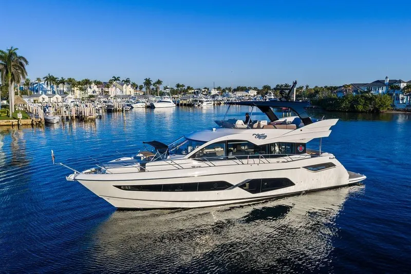 Slide: The Image of 2021 Sunseeker Manhattan 68 yacht cruising in a scenic marina with palm trees. - 3
