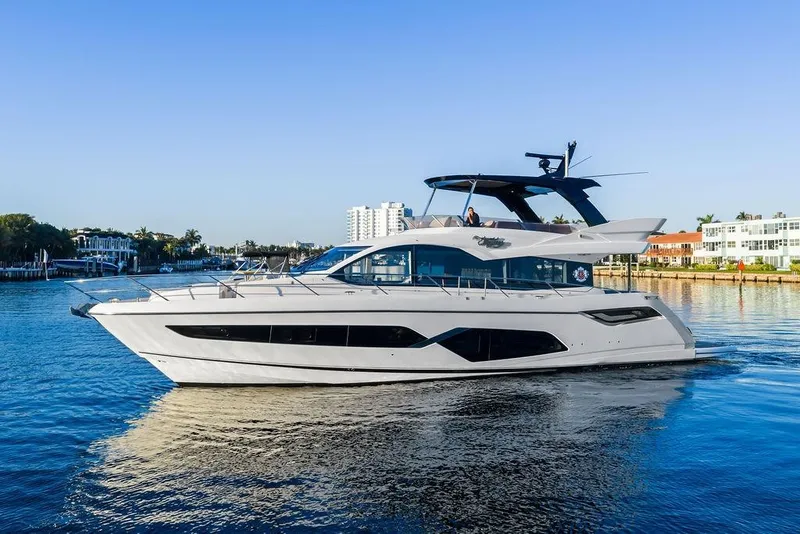 Slide: The Image of 2021 Sunseeker Manhattan 68 yacht cruising on a sunny day, near waterfront buildings. - 4