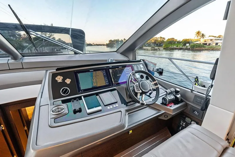 Slide: The Image of Helm of 2021 Sunseeker Manhattan 68 yacht with navigation controls and scenic water view. - 48