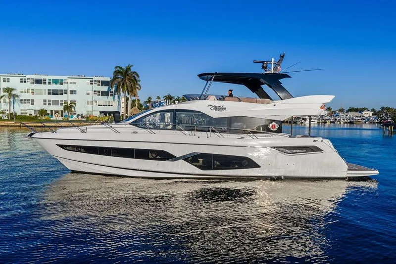 Slide: The Image of 2021 Sunseeker Manhattan 68 yacht cruising on a sunny day near waterfront buildings. - 5
