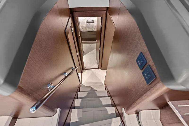 Slide: The Image of Staircase inside 2021 Sunseeker Manhattan 68 yacht, featuring sleek wooden design and modern fixtures. - 69