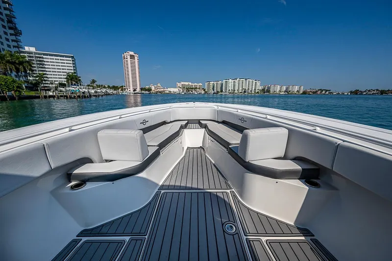 Slide: The Image of 2020 Fountain 38 Center Console boat with spacious seating, cruising near waterfront buildings. - 13