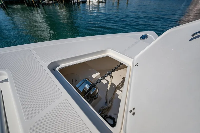 Slide: The Image of 2020 Fountain 38 Center Console anchor compartment with chain and rope, dockside view. - 18