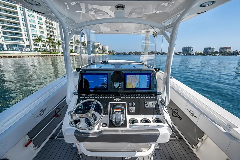 Slide: The Image of 2020 Fountain 38 Center Console boat dashboard with navigation screens on calm water. - 22