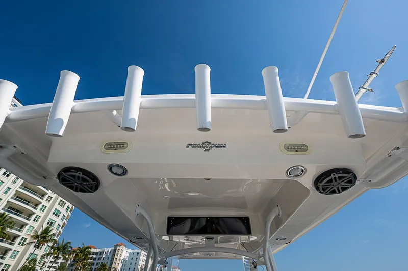 Slide: The Image of 2020 Fountain 38 Center Console boat with rod holders and speakers, under clear blue sky. - 23
