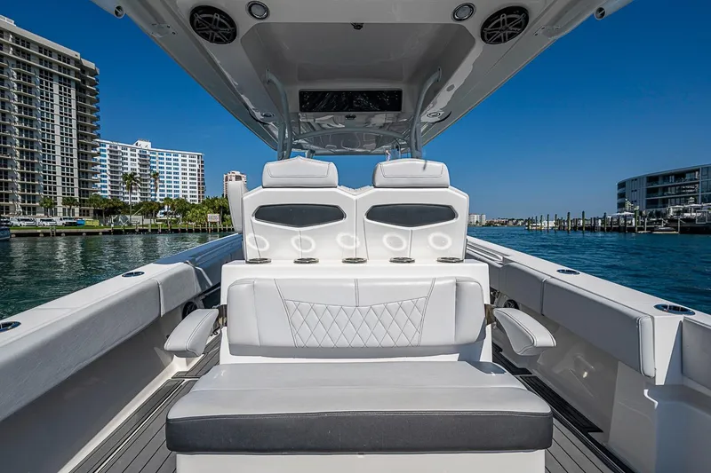 Slide: The Image of 2020 Fountain 38 Center Console boat interior with luxurious seating, docked near waterfront buildings. - 7