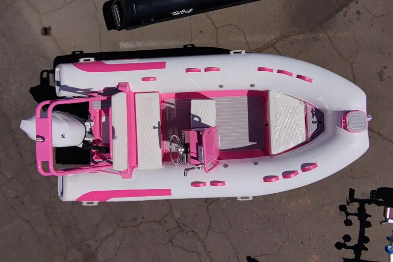 Slide: The Image of Aerial view of 2026 Tide Craft Custom Pink & White Catalina 13 boat on pavement. - 1