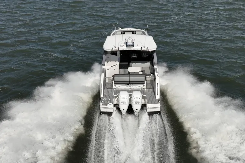 Slide: The Image of 2023 Galeon 325 GTO cruising on open water, rear view with powerful engines. - 6