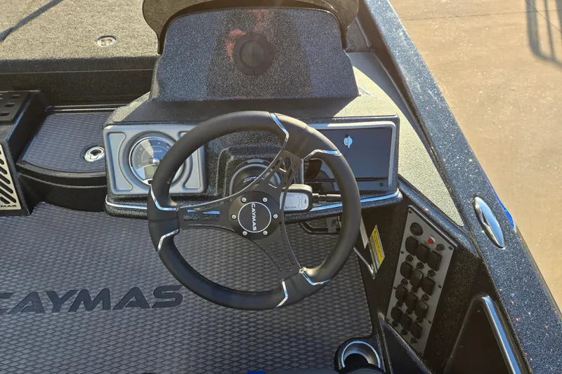 Slide: The Image of Steering wheel and dashboard of 2027 Caymas 201 Pro boat, featuring modern controls. - 5