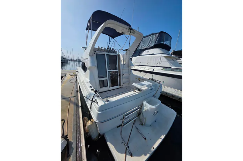 Slide: The Image of 2000 Bayliner 2858 Ciera Command Bridge docked at marina under clear blue sky. - 10