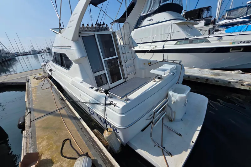 Slide: The Image of 2000 Bayliner 2858 Ciera Command Bridge docked at marina, rear view. - 11