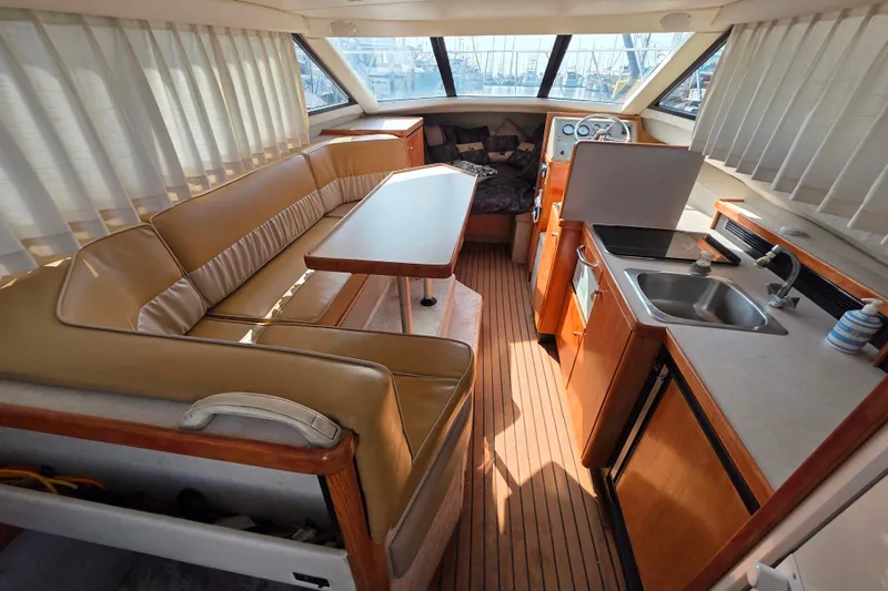 Slide: The Image of Interior of 2000 Bayliner 2858 Ciera Command Bridge with seating, table, and kitchenette. - 12