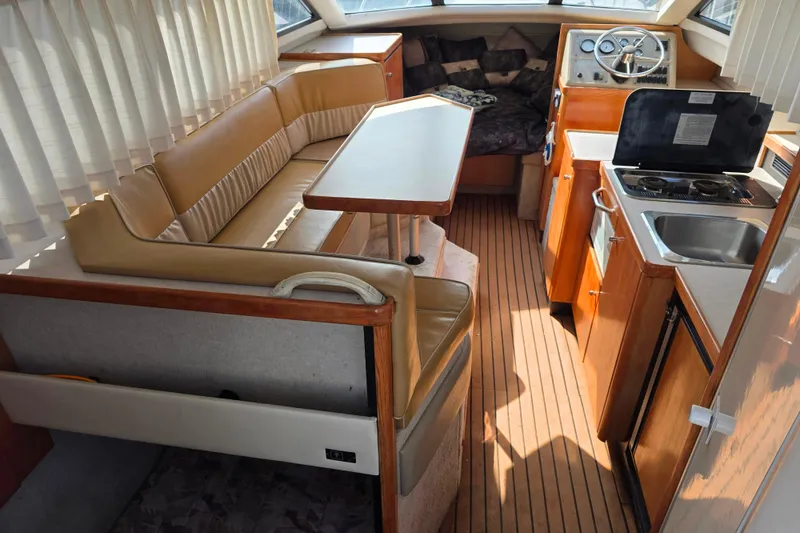 Slide: The Image of Interior of 1999 Bayliner 2858 Ciera Command Bridge with seating, table, and kitchenette. - 13