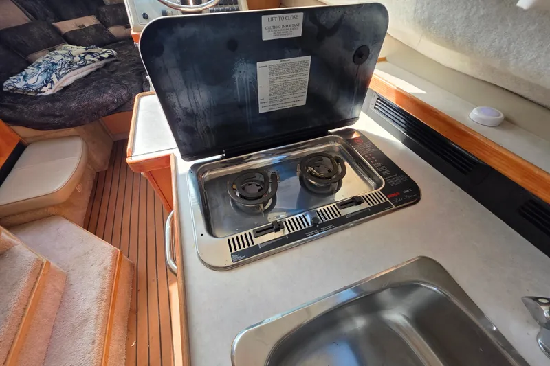 Slide: The Image of 1999 Bayliner 2858 Ciera Command Bridge interior with stove and seating area. - 15