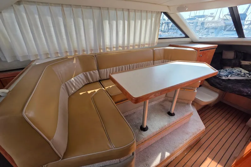 Slide: The Image of Interior of 1999 Bayliner 2858 Ciera Command Bridge with tan seating and dining table. - 16