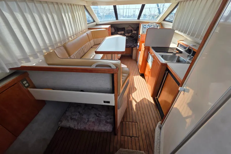 Slide: The Image of 1999 Bayliner 2858 Ciera Command Bridge interior with dining area and kitchenette. - 17