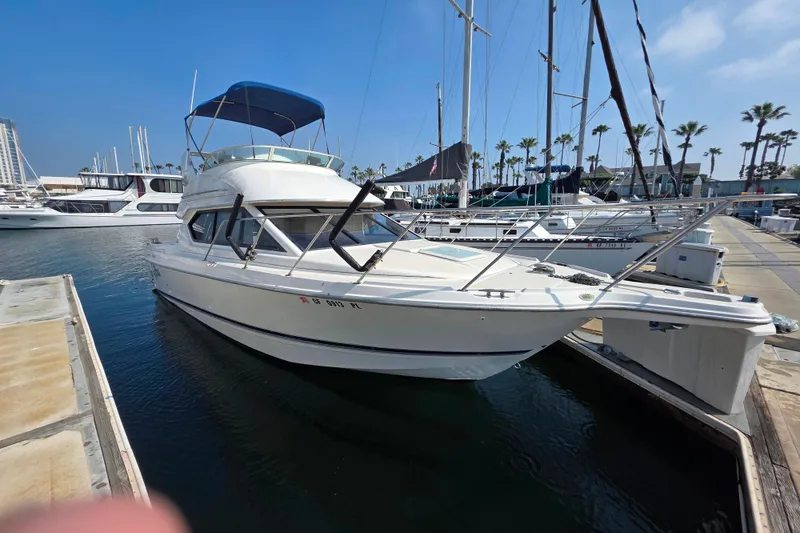 Slide: The Image of 2000 Bayliner 2858 Ciera Command Bridge docked at marina under clear blue sky. - 7