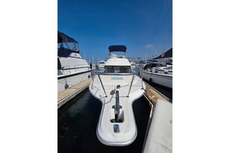 Slide: The Image of 2000 Bayliner 2858 Ciera Command Bridge docked at marina under clear blue sky. - 8