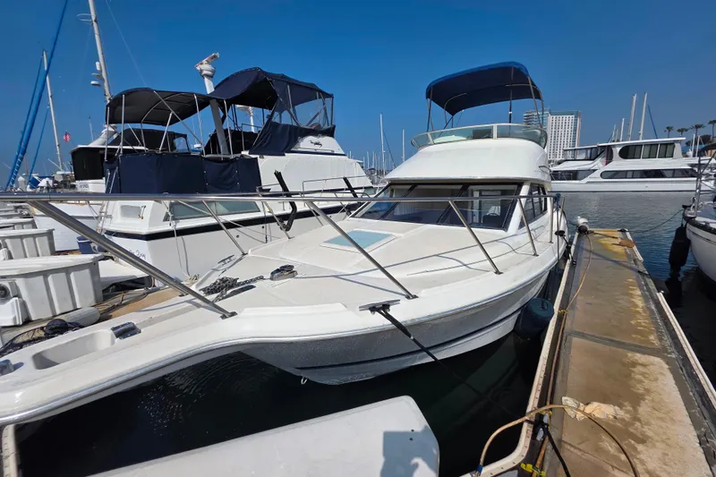 Slide: The Image of 2000 Bayliner 2858 Ciera Command Bridge docked at marina under clear blue sky. - 9