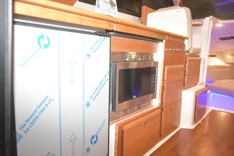 Slide: The Image of Interior of 2026 Cutwater C-32 CB boat featuring modern kitchen appliances and wooden cabinetry. - 11