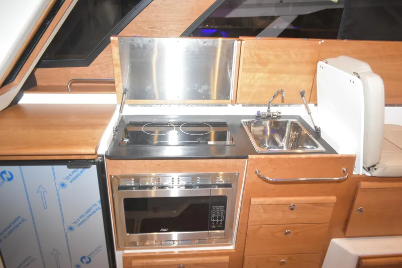 Slide: The Image of 2026 Cutwater C-32 CB yacht kitchen with stove, oven, and sink. - 13