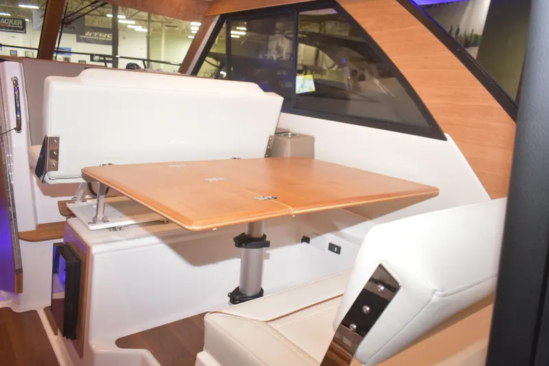 Slide: The Image of Interior of 2026 Cutwater C-32 CB boat with wooden table and white seating. - 17
