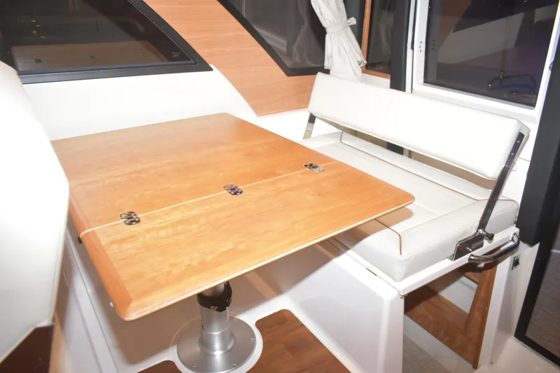 Slide: The Image of Interior of 2026 Cutwater C-32 CB boat with wooden table and white seating. - 18