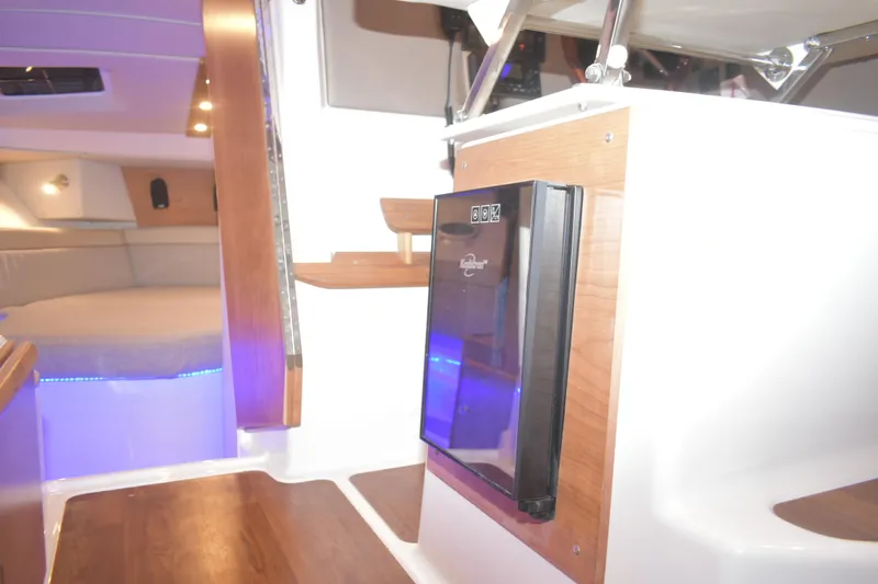 Slide: The Image of 2026 Cutwater C-32 CB interior with wood accents and compact refrigerator. - 20