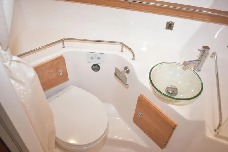 Slide: The Image of 2026 Cutwater C-32 CB boat bathroom with modern glass sink and wooden accents. - 25