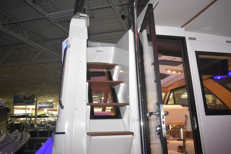 Slide: The Image of Staircase and interior view of 2026 Cutwater C-32 CB boat at an indoor showroom. - 34