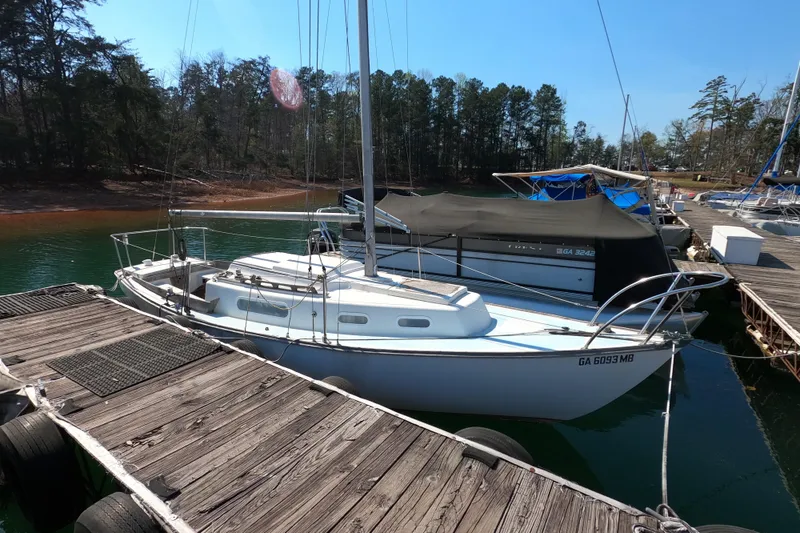 The Image of 1976 Cape Dory 25 sailboat docked at a marina, surrounded by trees. - 1