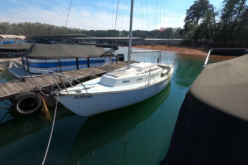 Slide: The Image of 1976 Cape Dory 25 sailboat docked on a serene lake with clear skies. - 3