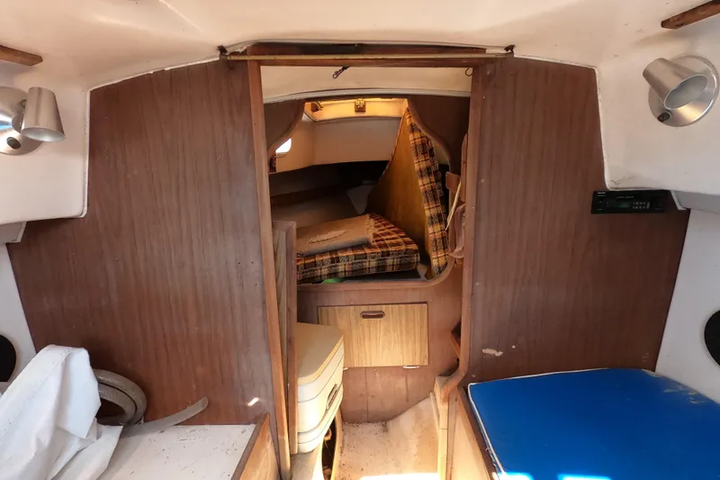 Slide: The Image of Interior of a 1976 Cape Dory 25 sailboat with wood paneling and plaid cushions. - 5