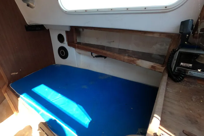 Slide: The Image of Interior of a 1976 Cape Dory 25 sailboat with blue seating and radio equipment. - 6