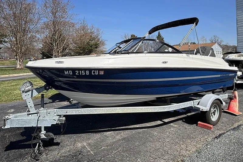 Slide: The Image of 2016 Bayliner 185 Bowrider on trailer, parked outdoors on a sunny day. - 1